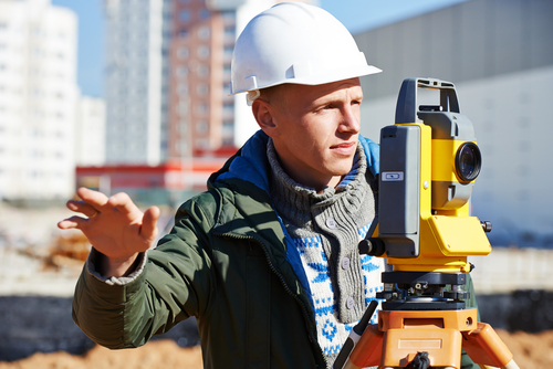 a man wearing a hard hat is looking through a telescope