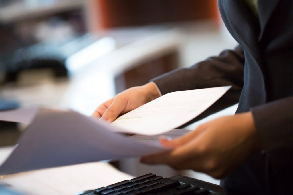 a person is holding papers in their hands