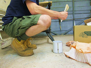 a man sitting on a bench with a brush in his hand