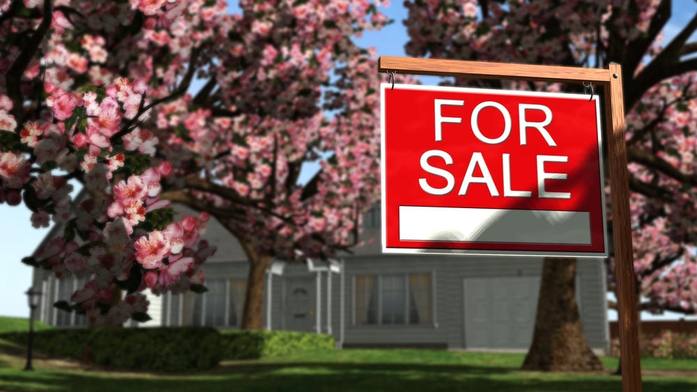 a red for sale sign in front of a house