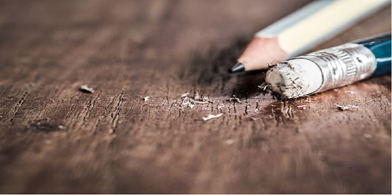 two pencils on a wooden table with shaving edges