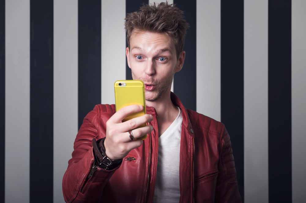 a man in a red leather jacket taking a selfie