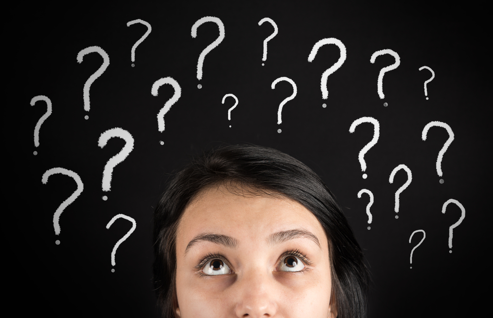 a woman looking up at question marks above her head