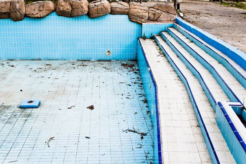 an empty swimming pool with blue and white tiles