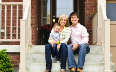 a man and woman sitting on the steps of a house