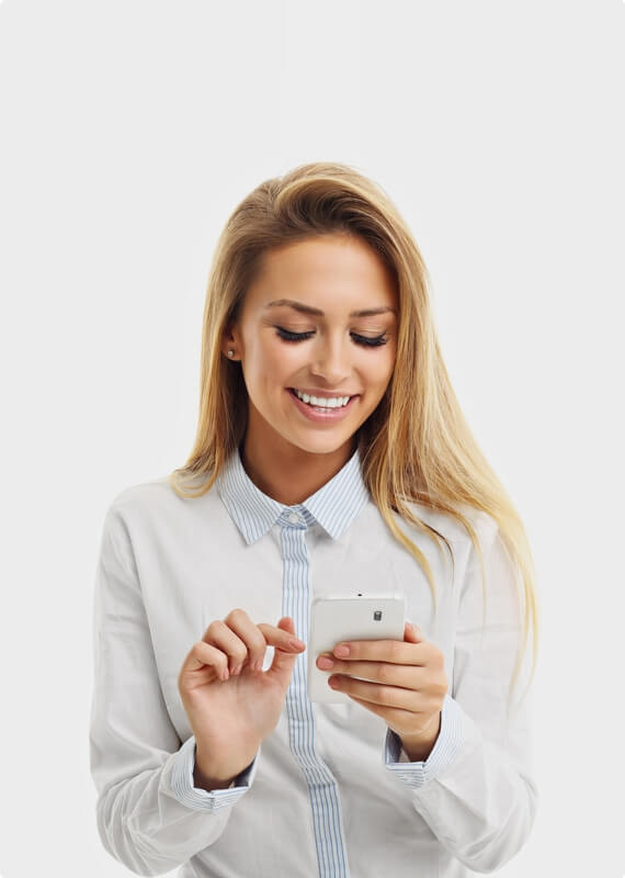 a woman is smiling while looking at her cell phone