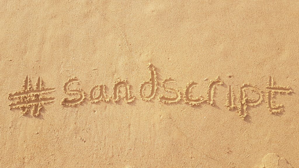 the word sandcastle written in the sand