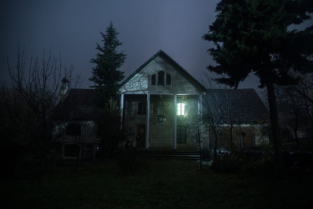 a house is lit up at night in the dark