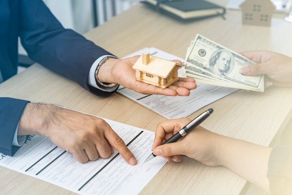 two people are sitting at a table with money