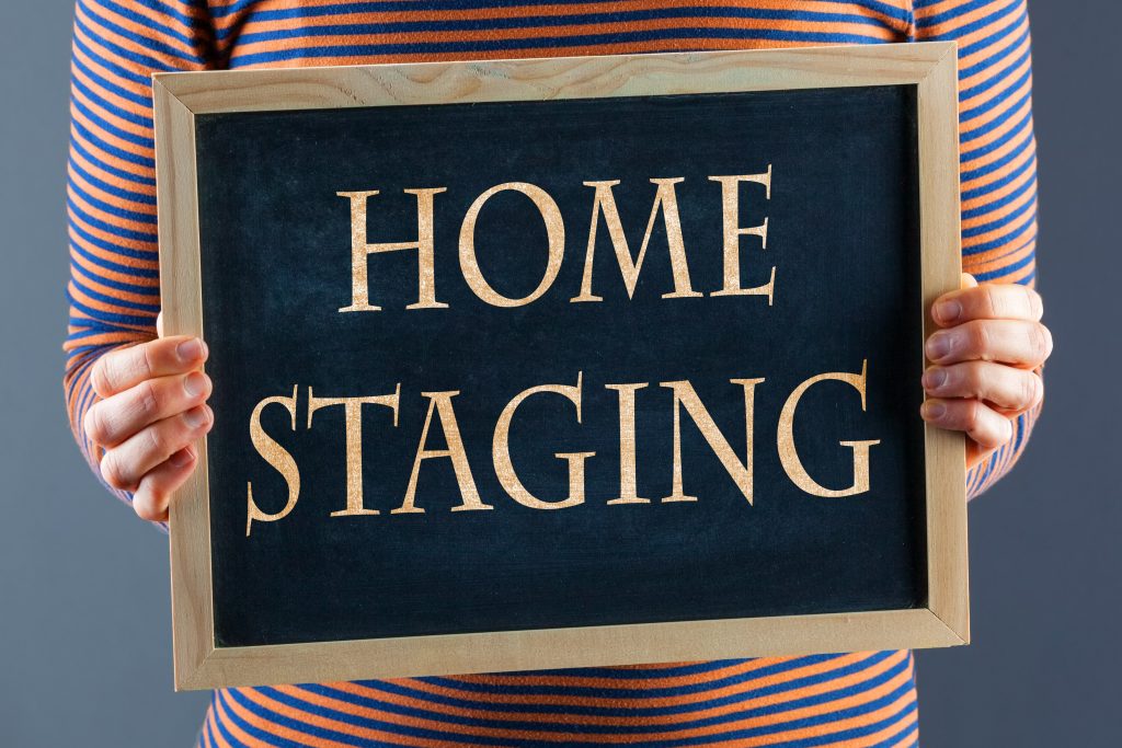 a person holding a sign that says home staging