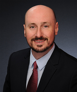 a man in a suit and tie smiling