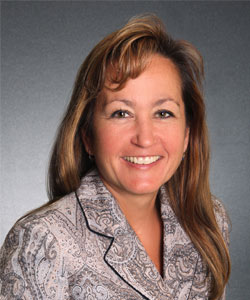 a woman with long hair wearing a paisley shirt