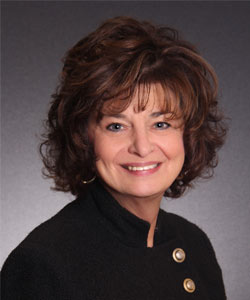 a woman in a black jacket smiling for the camera