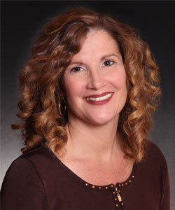 a woman with curly hair smiling at the camera