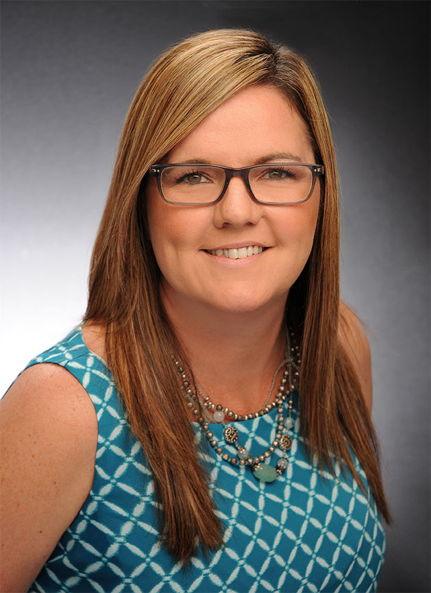 a woman wearing glasses and a blue top