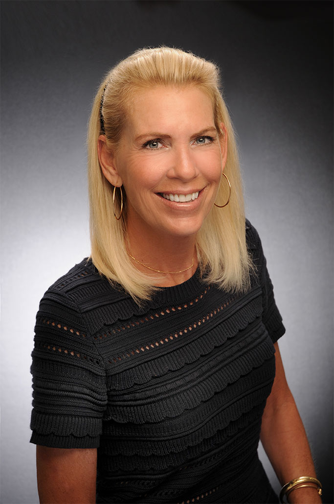 a woman with blonde hair smiling at the camera