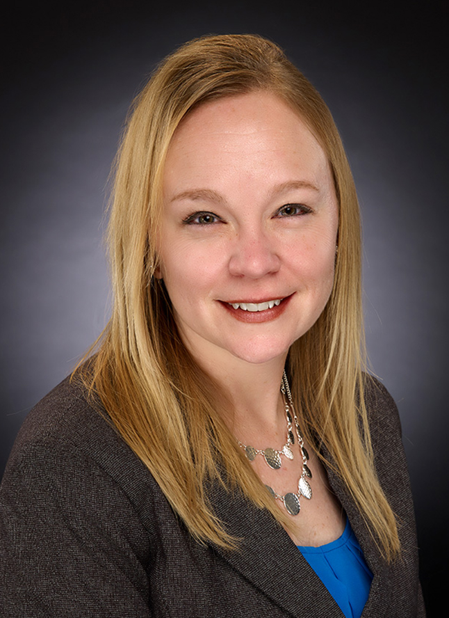 a woman with blonde hair wearing a gray jacket