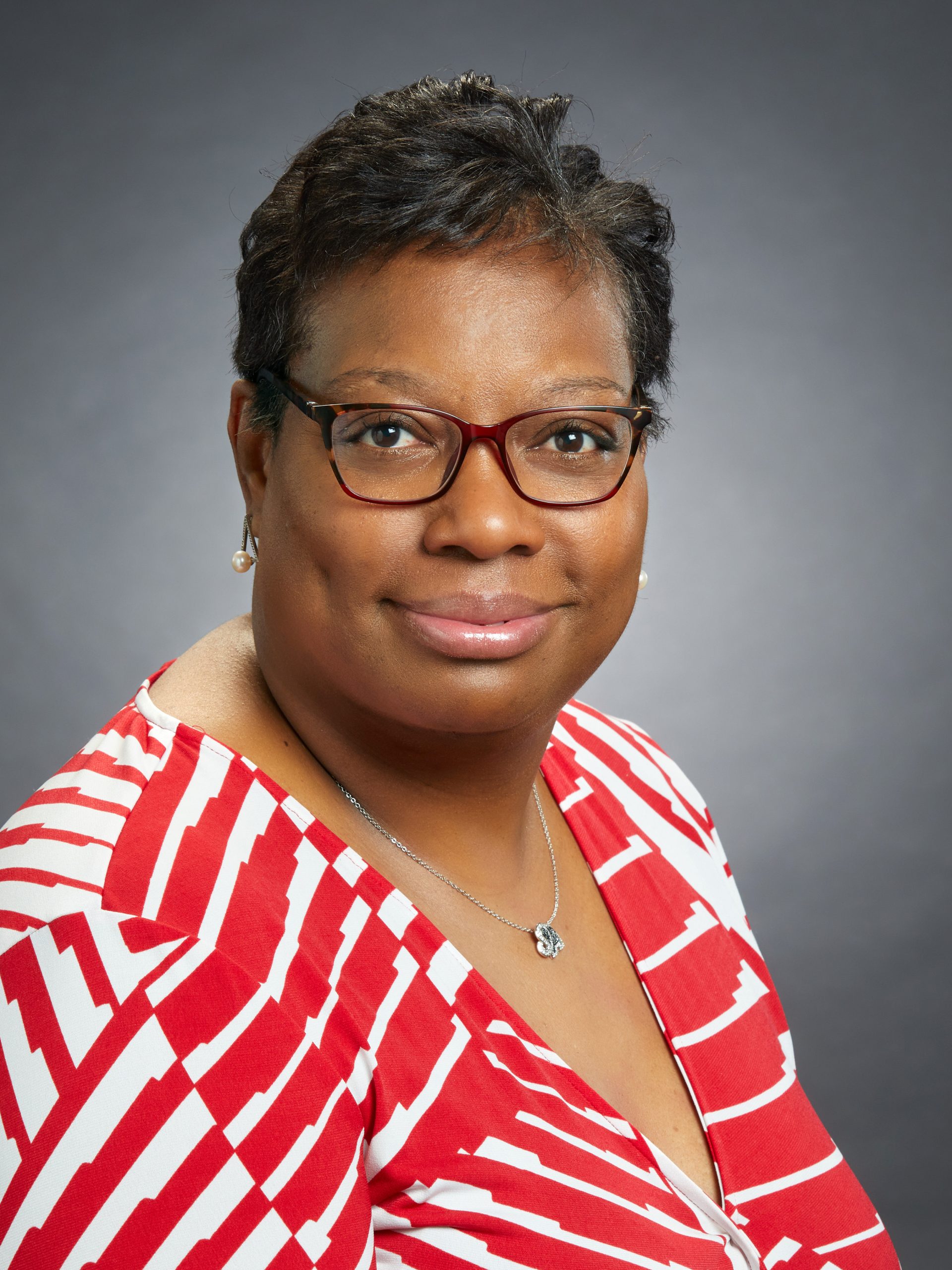 a woman wearing glasses and a red shirt