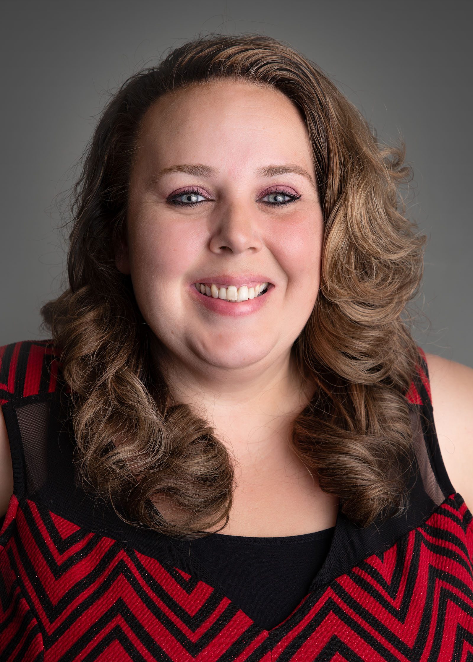 a woman in a red and black dress smiling