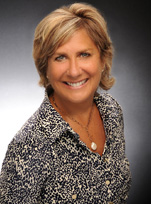 a woman in a blue shirt smiling for the camera