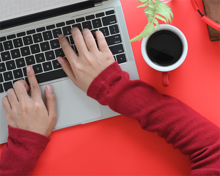 a person typing on a laptop with their hands