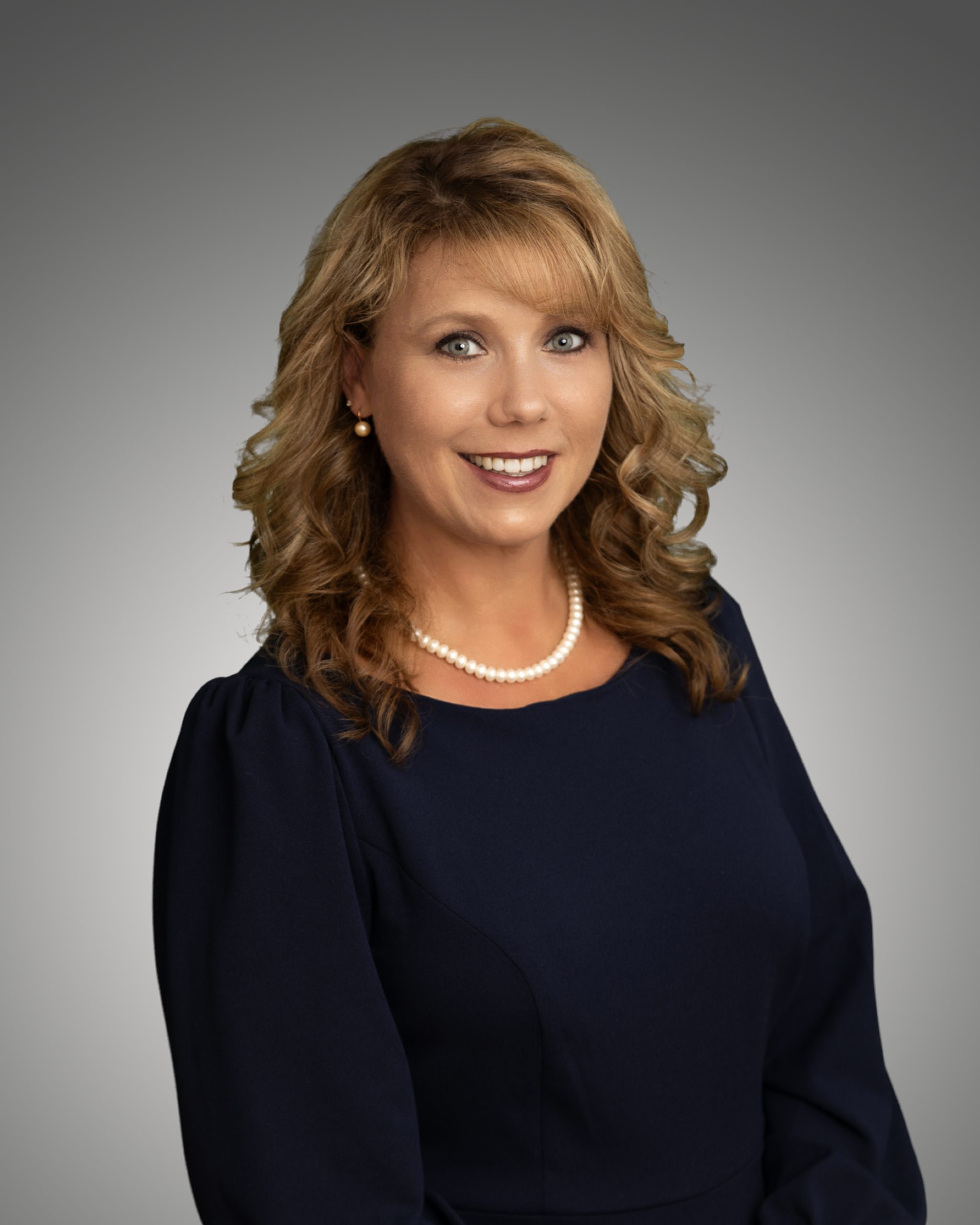 a woman in a black dress smiling for the camera