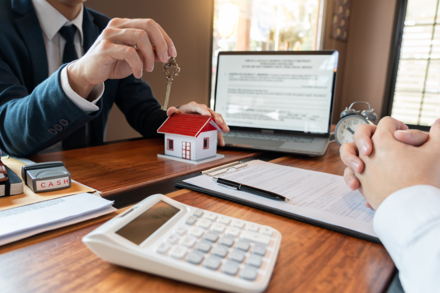 two people sitting at a table with keys in their hands